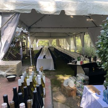 Réception de festival sous une grande tente blanche avec tables dressées et bar.