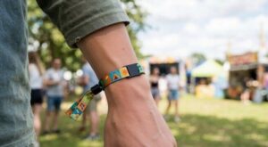 Bracelet de festival coloré noué autour d’un poignet dans un parc