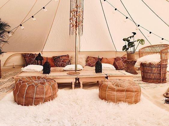 Espace chillout bohème sous une tente, avec poufs et tapis moelleux